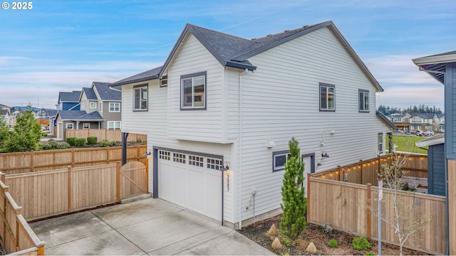 3985 SE Lostine Ln, Hillsboro, OR 97123 - view of side of home featuring an attached garage, driveway, and a residential view