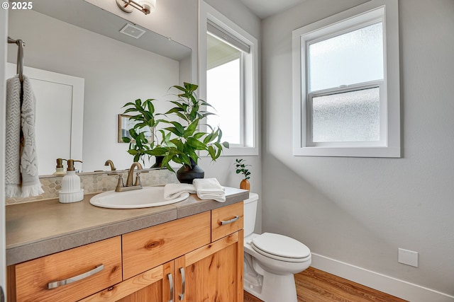3985 SE Lostine Ln, Hillsboro, OR 97123 - bathroom featuring toilet, vanity, wood finished floors, and baseboards