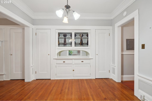 bar with crown molding, wood finished floors, and a chandelier