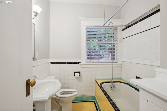 bathroom featuring a sink, a bathing tub, toilet, and tile walls