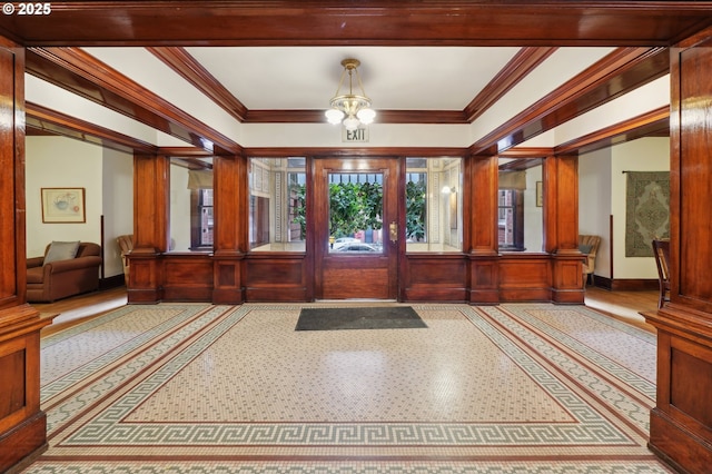 entrance foyer featuring crown molding, decorative columns, and baseboards