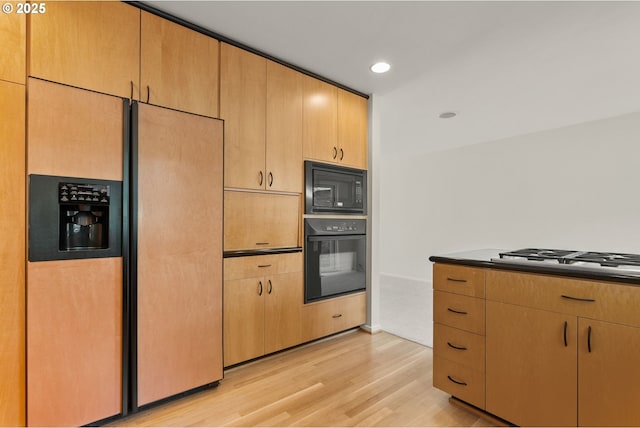 kitchen featuring recessed lighting, dark countertops, light wood finished floors, and black appliances