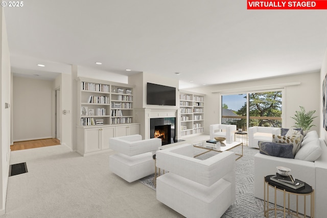 living area featuring carpet flooring, recessed lighting, visible vents, and a fireplace