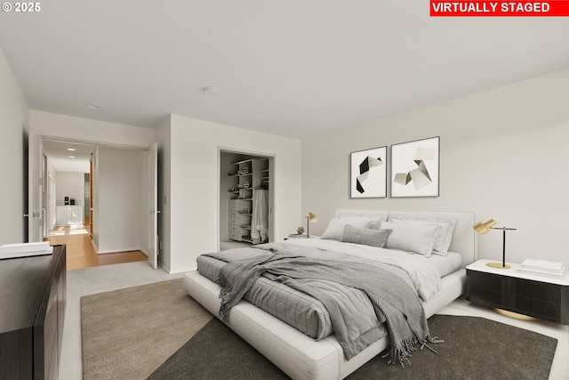 bedroom with light carpet, a closet, and a spacious closet