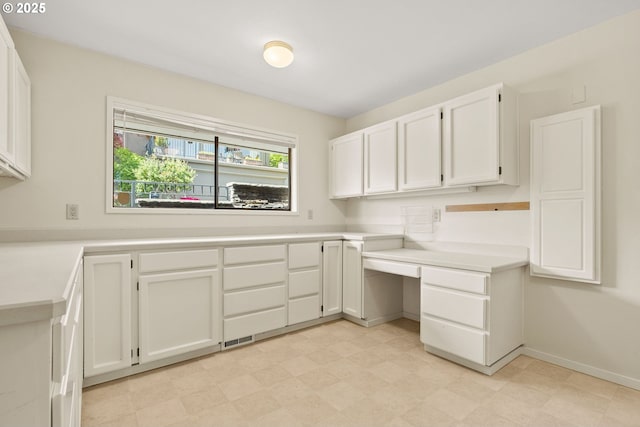 laundry area featuring baseboards, visible vents, and light floors