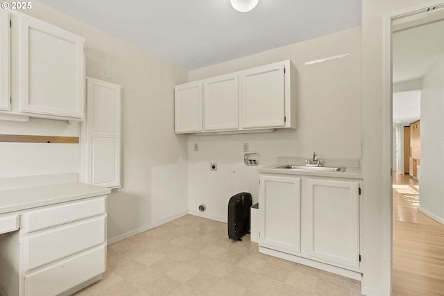 washroom with washer hookup, hookup for an electric dryer, cabinet space, a sink, and light floors