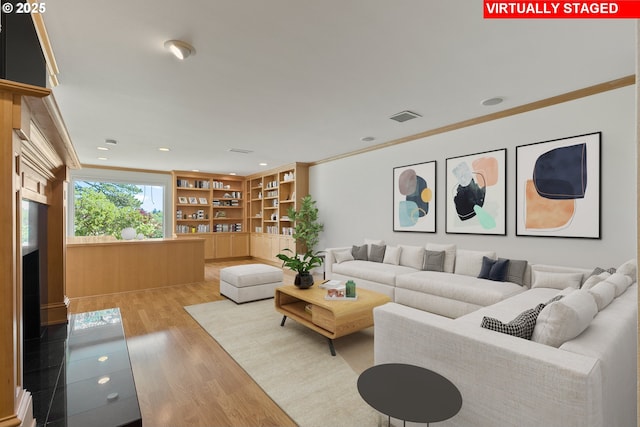 living room with ornamental molding, recessed lighting, wood finished floors, and visible vents