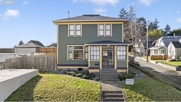 traditional style home with a front yard and fence