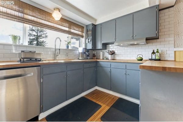 1508 Union Ave, North Bend, OR 97459 - kitchen with stainless steel dishwasher, under cabinet range hood, healthy amount of natural light, and tasteful backsplash
