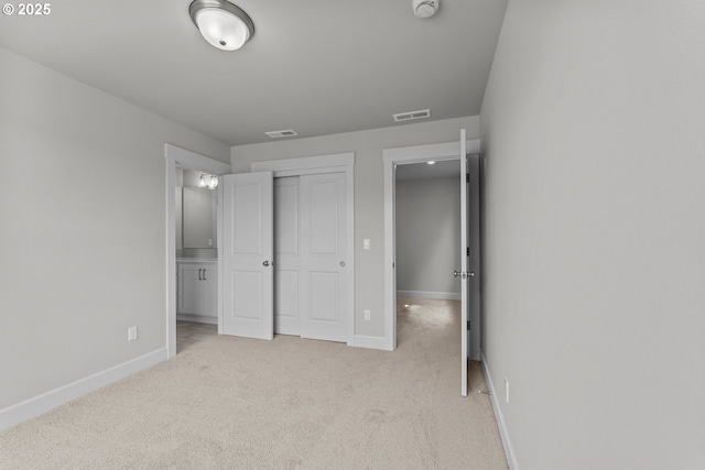 unfurnished bedroom featuring carpet floors, baseboards, visible vents, and a closet