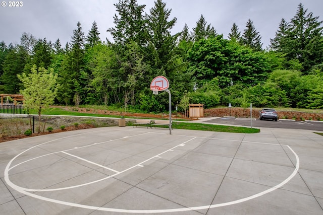 view of sport court featuring a shed, community basketball court, and fence