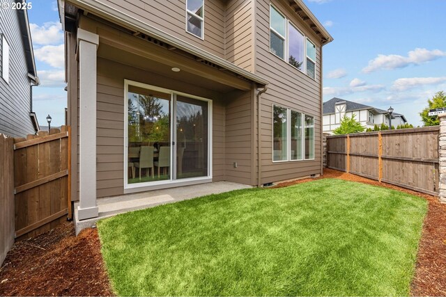back of property featuring a lawn, a fenced backyard, and a patio area