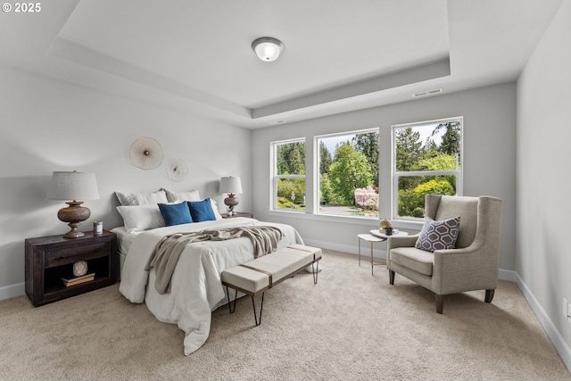 bedroom featuring baseboards, a tray ceiling, carpet flooring, and visible vents