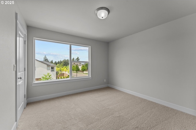 empty room featuring baseboards and carpet