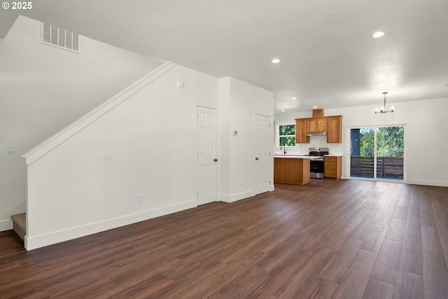48438 E Meadow Way, Oakridge, OR 97463 - unfurnished living room with a chandelier, dark wood-style flooring, recessed lighting, and stairway