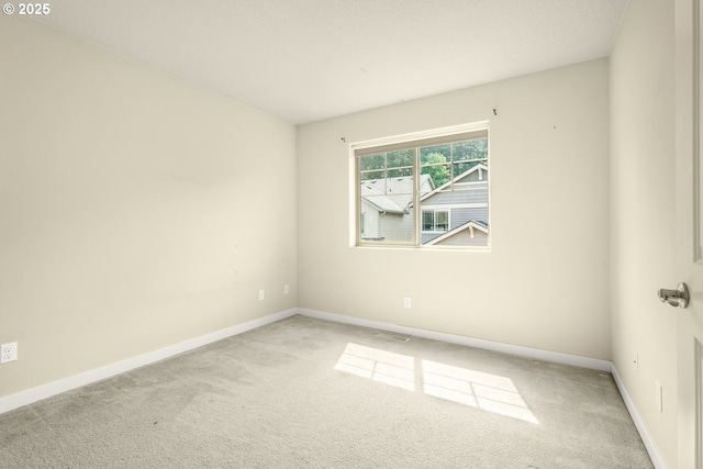 carpeted spare room with baseboards and visible vents