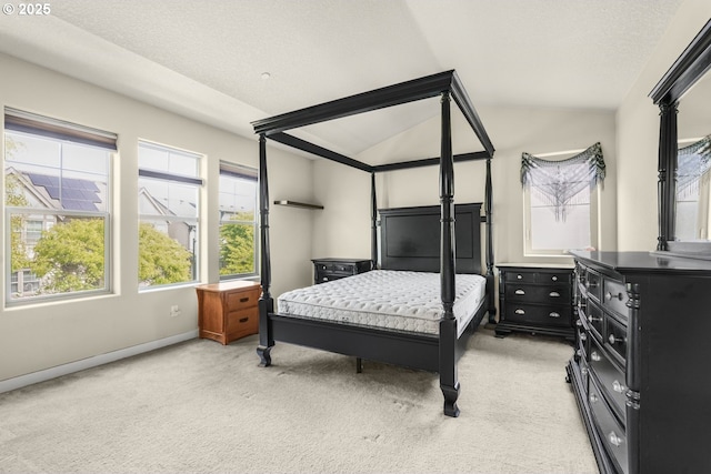 bedroom featuring baseboards, light carpet, and lofted ceiling