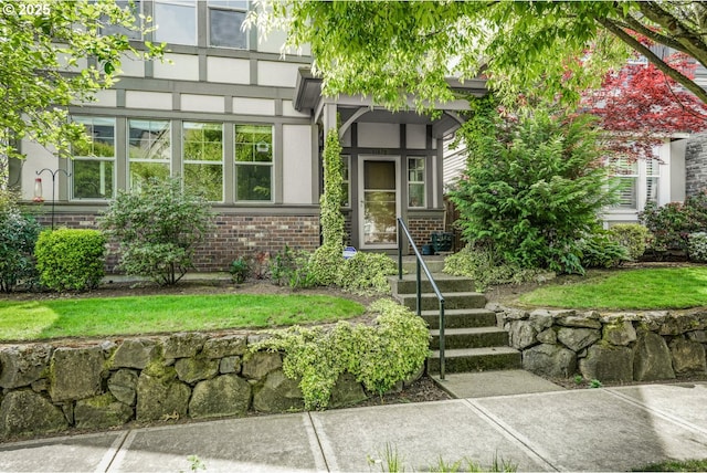 doorway to property with brick siding and stucco siding