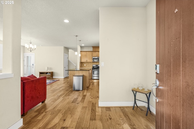 interior space with recessed lighting, baseboards, a notable chandelier, and light wood-type flooring