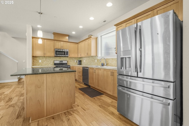 kitchen with backsplash, visible vents, appliances with stainless steel finishes, a sink, and light wood finished floors