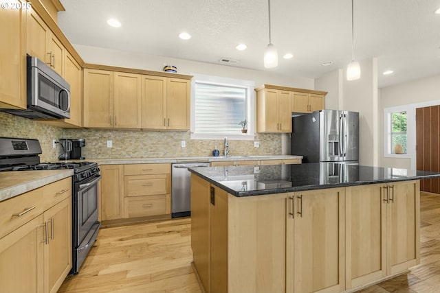 kitchen featuring a sink, light wood finished floors, light brown cabinets, stainless steel appliances, and tasteful backsplash