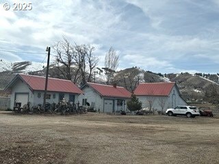 view of front of house featuring a front lawn, an outbuilding, and a garage