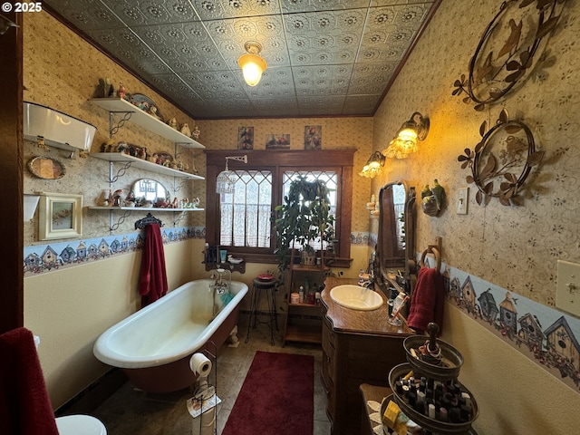 full bath featuring a freestanding bath, an ornate ceiling, wallpapered walls, and vanity