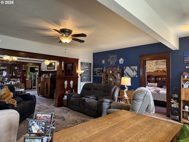 living room featuring ceiling fan with notable chandelier