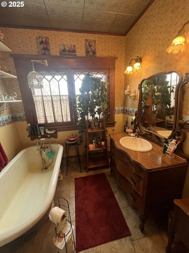 full bath with an ornate ceiling, wallpapered walls, vanity, and a freestanding tub