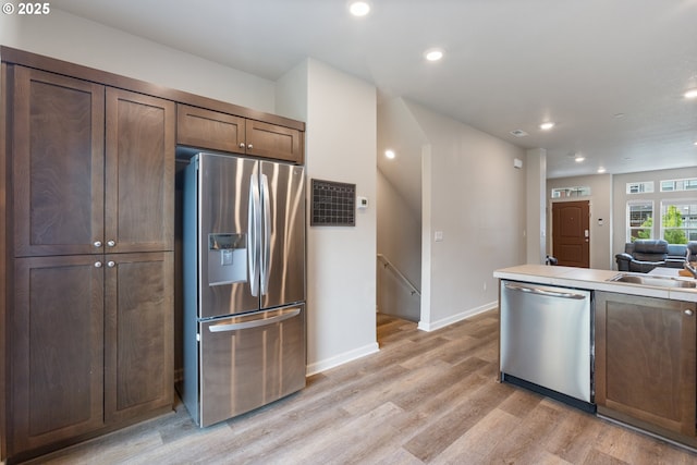 11449 SW Mont Blanc St, Wilsonville, OR 97070 - kitchen featuring appliances with stainless steel finishes, light wood-type flooring, baseboards, a sink, and recessed lighting