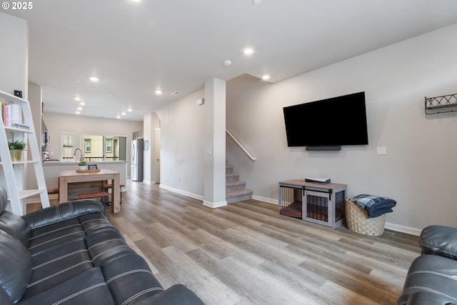 11449 SW Mont Blanc St, Wilsonville, OR 97070 - living room with light wood-type flooring, stairs, recessed lighting, and baseboards