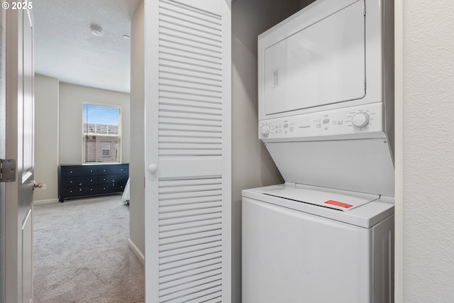 11449 SW Mont Blanc St, Wilsonville, OR 97070 - laundry room with stacked washer / dryer, carpet, and baseboards