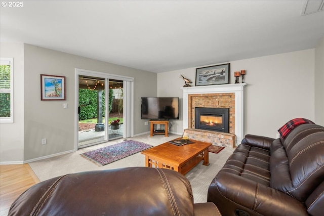 living room with a brick fireplace, baseboards, and visible vents