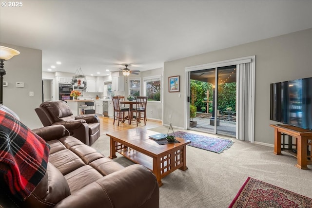 living room with a ceiling fan, recessed lighting, light carpet, and baseboards