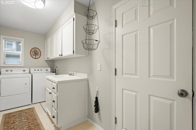 clothes washing area with washer and dryer, cabinet space, a sink, and baseboards