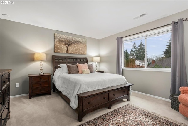 bedroom with baseboards, visible vents, and light colored carpet