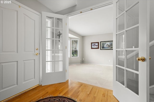 foyer with lofted ceiling, french doors, and wood finished floors