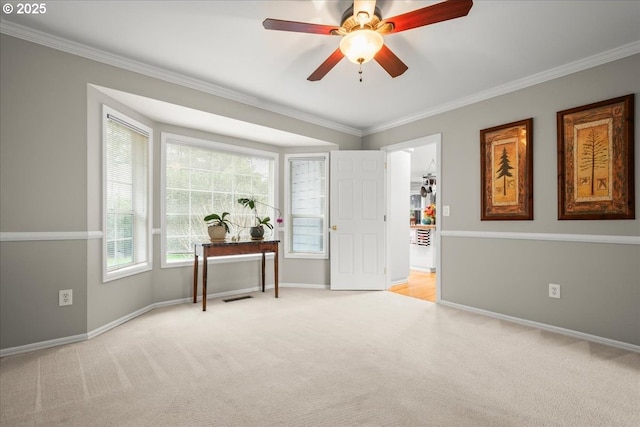 spare room with baseboards, ornamental molding, and light colored carpet