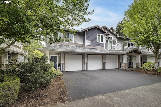 view of front of house featuring an attached garage, stone siding, and aphalt driveway