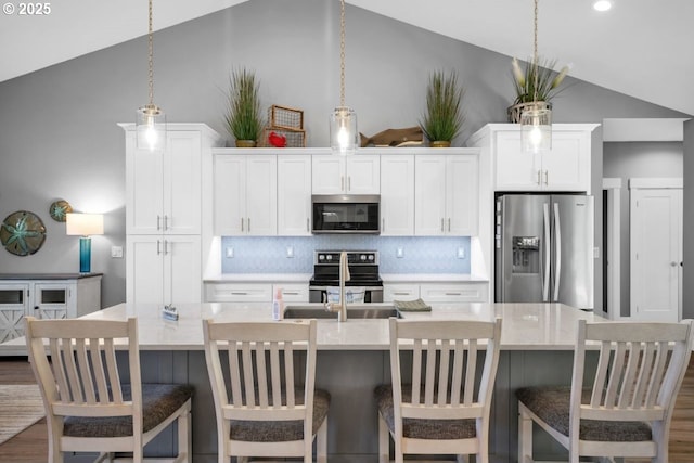 83591 Sauter Dr, Florence, OR 97439 - kitchen featuring stainless steel appliances, vaulted ceiling, backsplash, light countertops, and white cabinets