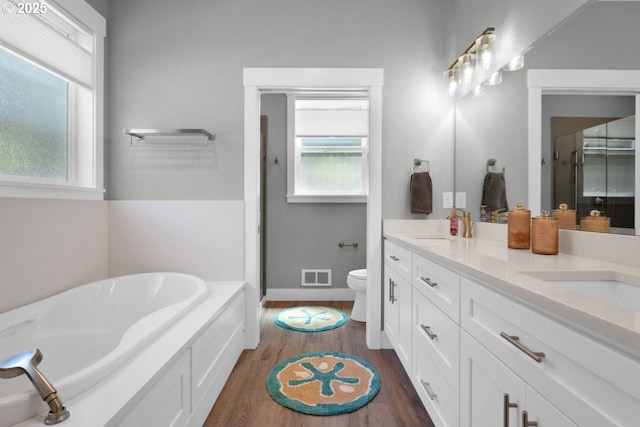 83591 Sauter Dr, Florence, OR 97439 - full bathroom featuring double vanity, wood finished floors, a garden tub, and a stall shower