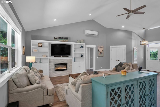 83591 Sauter Dr, Florence, OR 97439 - living room with a wall mounted air conditioner, high vaulted ceiling, wood finished floors, a fireplace, and a ceiling fan