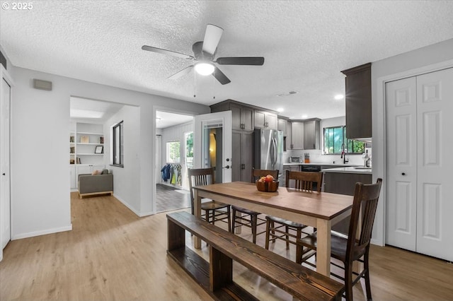 9532 SW Whitford Ln, Beaverton, OR 97008 - dining room with a ceiling fan, a textured ceiling, light wood-style flooring, and baseboards