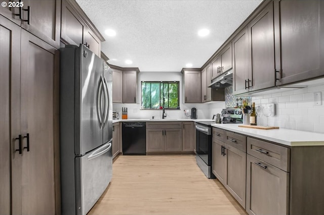 9532 SW Whitford Ln, Beaverton, OR 97008 - kitchen featuring appliances with stainless steel finishes, light wood-type flooring, decorative backsplash, recessed lighting, and a textured ceiling