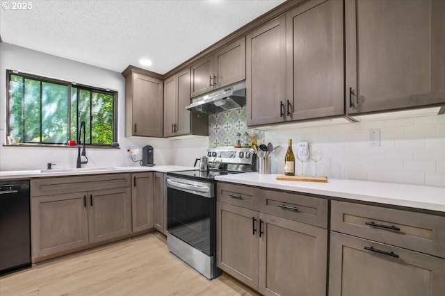 9532 SW Whitford Ln, Beaverton, OR 97008 - kitchen with under cabinet range hood, stainless steel electric stove, a sink, black dishwasher, and light wood-type flooring