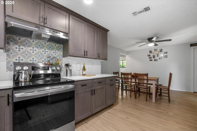 9532 SW Whitford Ln, Beaverton, OR 97008 - kitchen with electric range, under cabinet range hood, light wood-style flooring, tasteful backsplash, and light countertops