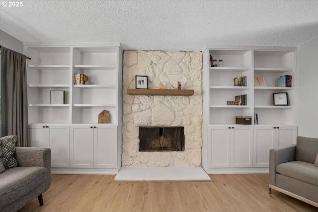 9532 SW Whitford Ln, Beaverton, OR 97008 - living area with wood finished floors, a textured ceiling, and a fireplace