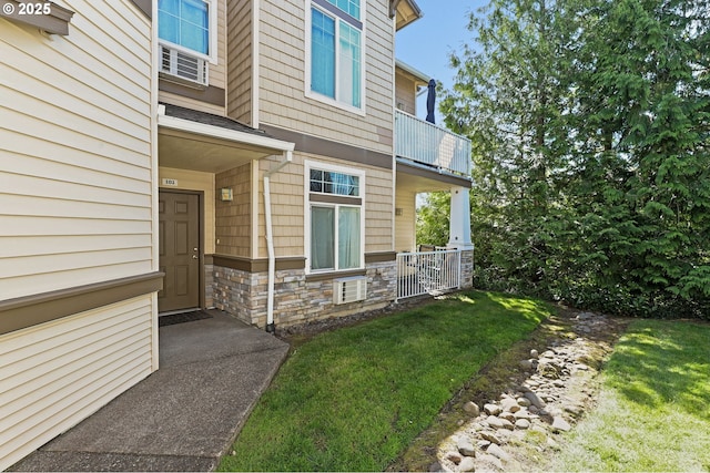 14600 SW Magpie Ln Unit 102, Beaverton, OR 97007 - doorway to property with a balcony, stone siding, and a lawn