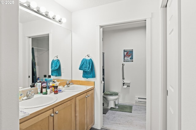 14600 SW Magpie Ln Unit 102, Beaverton, OR 97007 - bathroom with a baseboard heating unit, double vanity, and toilet