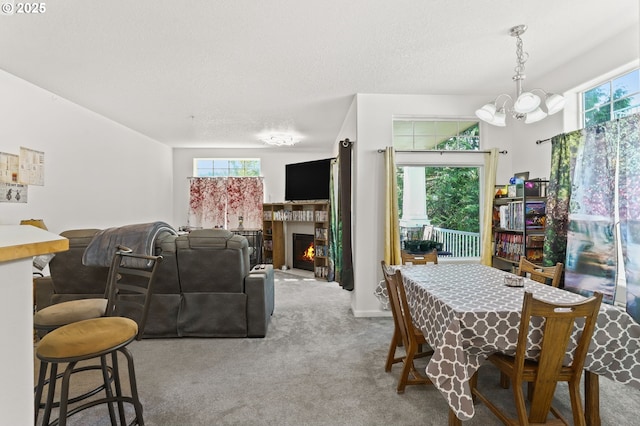 14600 SW Magpie Ln Unit 102, Beaverton, OR 97007 - carpeted dining room with healthy amount of natural light, a chandelier, a warm lit fireplace, and a textured ceiling